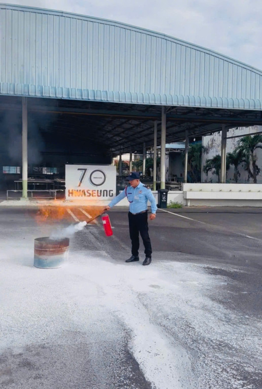 Bảo vệ dập tắt đám cháy lửa lớn với bình cứu hỏa tại công ty Hwaseung Vina.