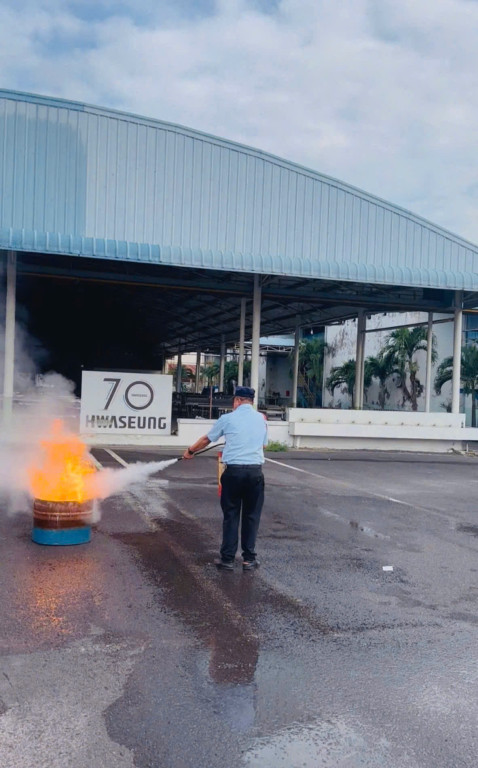 Bảo vệ dập tắt đám cháy lửa lớn với bình cứu hỏa tại công ty Hwaseung Vina.